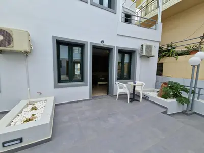 a patio with a table and chairs and a building at Rainbow Hotel Apartments in Chania Town