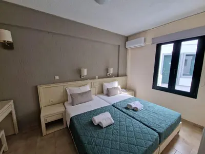 a bedroom with a bed with towels on it at Rainbow Hotel Apartments in Chania Town