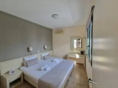 a bedroom with a large white bed in a room at Rainbow Hotel Apartments in Chania Town