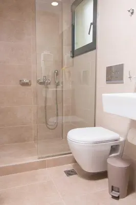 a bathroom with a shower and a toilet and a sink at Rainbow Hotel Apartments in Chania Town