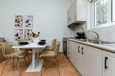 a kitchen with a table and chairs and a sink at Elafonisi - Cretan Serenity - Private Pool in Elafonisi