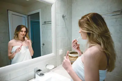 a woman brushing her teeth in front of a mirror at Elafonisi - Cretan Serenity - Private Pool in Elafonisi