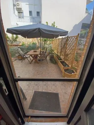 an open door with an umbrella on a patio at Kristy's House with garden in Chania Town