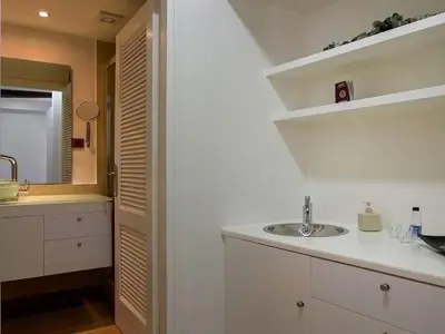 a white bathroom with a sink and a mirror at Waves - Seaside Escape in Chania Town
