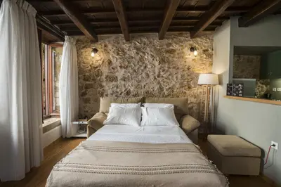 a bedroom with a bed and a stone wall at Eulogia Casa in Chania Town