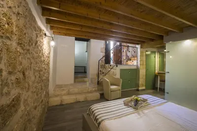 a bedroom with a bed and a stone wall at Eulogia Casa in Chania Town