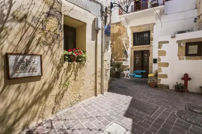 an alley in an old town with flowers in a window at Eulogia Casa in Chania Town