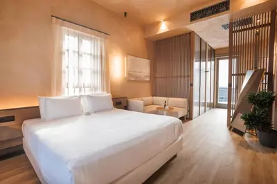 a bedroom with a large white bed and a couch at Nearchou Boutique Hotel in Chania Town