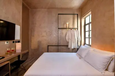a bedroom with a large white bed and a window at Nearchou Boutique Hotel in Chania Town