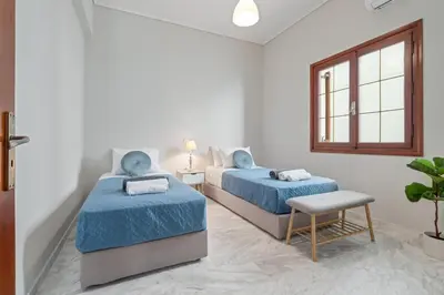 two beds in a white room with blue sheets at STR Sodi The View in Chania Town