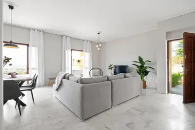 a white living room with a couch and a table at STR Sodi The View in Chania Town