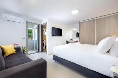 a bedroom with a large white bed and a couch at Kappa Apartment in Chania Town