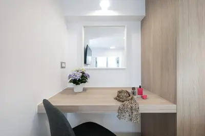 a desk in a room with a mirror and flowers at Kappa Apartment in Chania Town