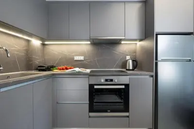 a kitchen with white cabinets and a stove top oven at Kappa Apartment in Chania Town