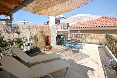a patio with chairs and a table and an umbrella at La Fiora Old Town Chania in Chania Town