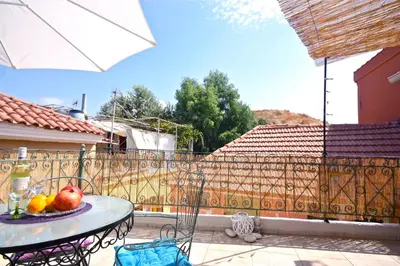 a table with fruit on a patio with a fence at La Fiora Old Town Chania in Chania Town