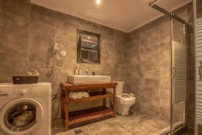 a bathroom with a sink and a washing machine at Seli Chrysi - Apartment near the Sea in Kámbos