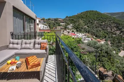 a balcony with a couch and a table on a balcony at Seli Chrysi - Apartment near the Sea in Kámbos