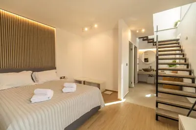 a white bedroom with a bed and a staircase at Venetian Villa by PosarelliVillas in Vamos