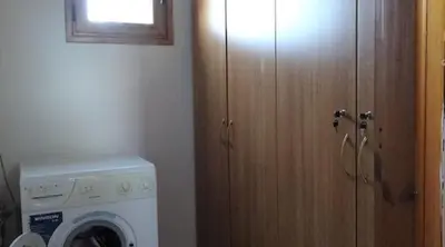 a kitchen with a washing machine and a wooden door at Villa Oneiro Tsivaras in Tsivarás