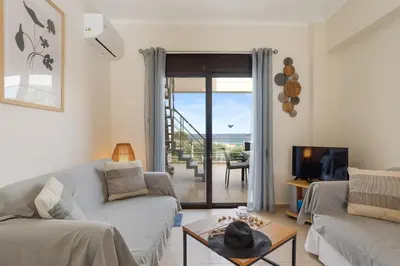 a living room with a couch and a tv at Almyrida Bay View House V BY APOKORONAS-VILLAS in Almirida