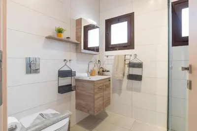 a bathroom with a toilet and a sink and a shower at Almyrida Bay View House V BY APOKORONAS-VILLAS in Almirida