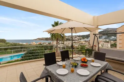 a table and chairs on a balcony with a view of the ocean at Almyrida Bay View House V BY APOKORONAS-VILLAS in Almirida