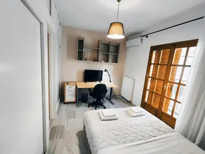 a bedroom with a bed and a desk with a computer at Coastal Retreat in Nea Chora in Chania Town