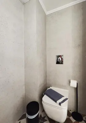 a bathroom with a toilet with a blue towel on it at Coastal Retreat in Nea Chora in Chania Town