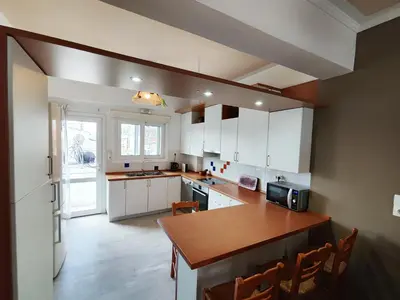 a kitchen with white cabinets and a wooden counter top at Coastal Retreat in Nea Chora in Chania Town