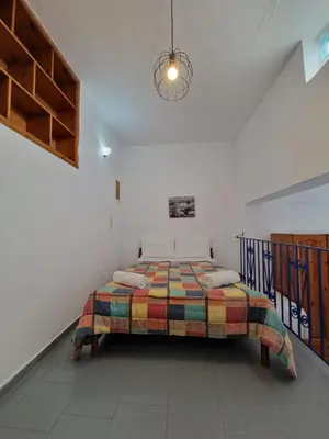 a bedroom with a bed with a colorful blanket at Stefanos Garden in Arménoi