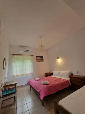 a bedroom with a large bed and a window at Stefanos Garden in Arménoi