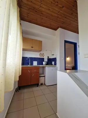 a kitchen with blue walls and a wooden ceiling at Stefanos Garden in Arménoi