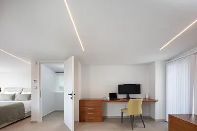 a bedroom with a bed and a desk with a television at Blue Olive Luxury Villa in Kounoupidhianá
