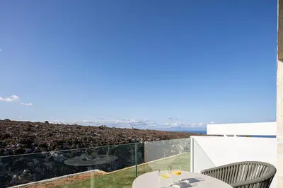 a view from the balcony of a house with a table and chairs at Blue Olive Luxury Villa in Kounoupidhianá