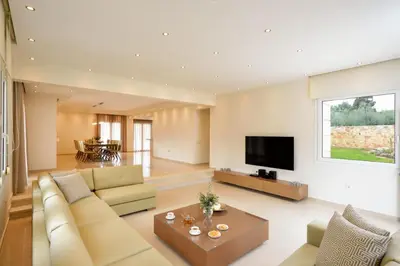 a living room with a couch and a tv at Villa Melitini in Souda