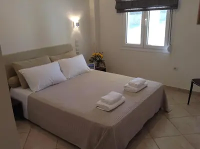 a bedroom with a large bed with towels on it at Villa Melitini in Souda