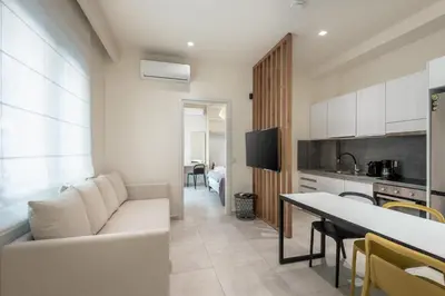 a living room with a white couch and a kitchen at Harma City Living in Chania Town