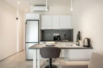 a kitchen with white cabinets and a kitchen island with a bowl on it at Harma City Living in Chania Town
