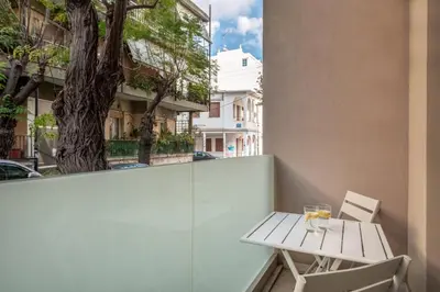 a table and chairs on a balcony with a tree at Harma City Living in Chania Town