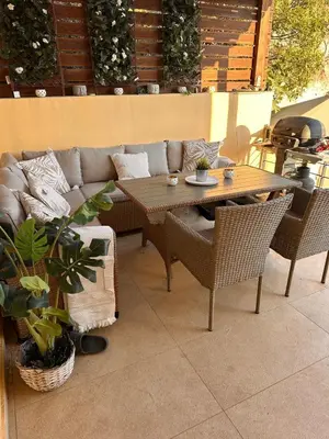 a patio with a couch and a table and chairs at Aegean View Villa, 2-min Drive to Almyrida Beach in Almirida