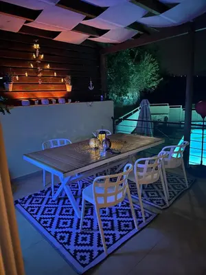 a wooden table and chairs on a patio at Aegean View Villa, 2-min Drive to Almyrida Beach in Almirida
