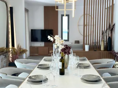 a long table with plates and wine glasses on it at Villa Eleni, Vamos Sea & Mountain View with Pool in Chania