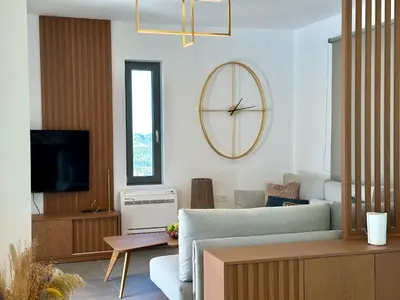 a living room with a large clock on the wall at Villa Eleni, Vamos Sea & Mountain View with Pool in Chania