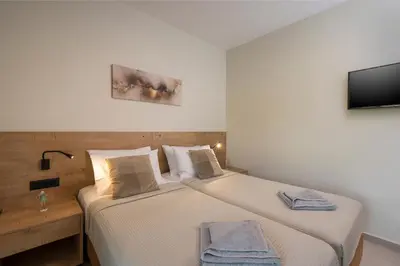 two beds in a small room with a television at Villa JOY in Módhion