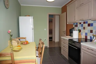 a kitchen with a table and a refrigerator at Seaside Cottage in Kato Daratso