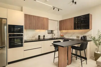 a kitchen with white cabinets and a black counter top at Lovelia Luxury Apartment Chania EV Car Wallbox in Chania Town