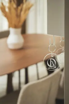 a key chain hanging from a table with a chair at Lovelia Luxury Apartment Chania EV Car Wallbox in Chania Town