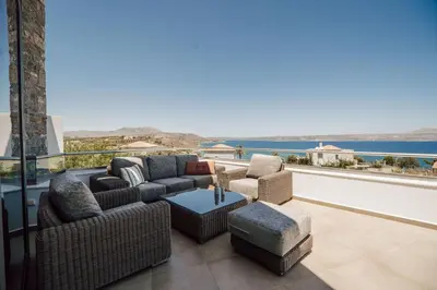 a patio with two couches and a table and chairs at Villa Kera Panorama by PosarelliVillas in Vamos