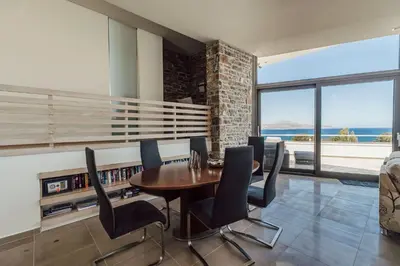 a dining room with a table and black chairs at Villa Kera Panorama by PosarelliVillas in Vamos